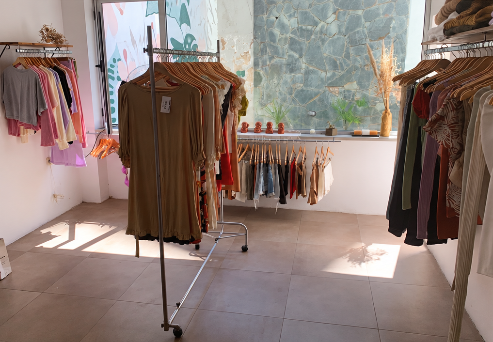 Local antes: percheros sueltos y ropa distribuida sin orden frente al ventanal